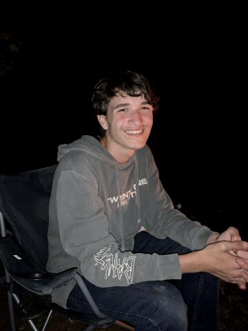 Wyatt smiling by campfire